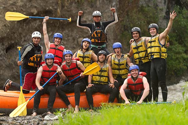 Rafting team navigating river rapids